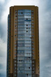 A large high-rise building against a blue sky on a construction site