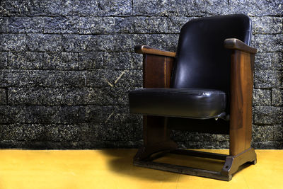 Empty chairs and table against wall