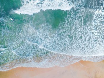 High angle view of sea waves splashing on beach