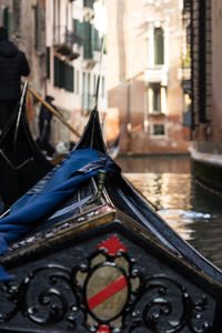 Close-up of boat moored in canal by buildings