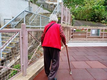 Rear view of man walking on footpath