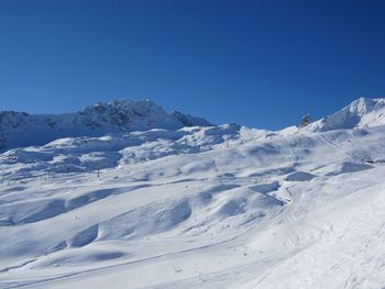 Scenic view of snowcapped mountains against clear blue sky