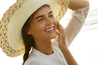 Portrait of young woman wearing hat standing at home