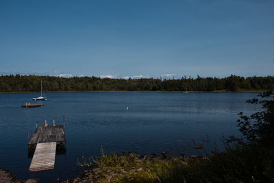 Scenic view of lake against clear blue sky