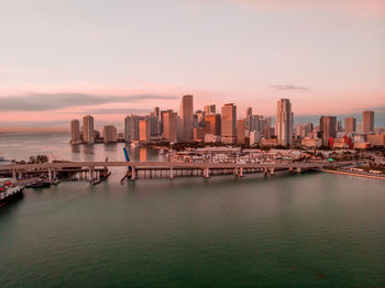 Modern buildings in city against sky during sunset