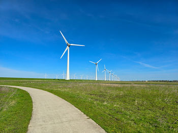 Windmills on field against sky