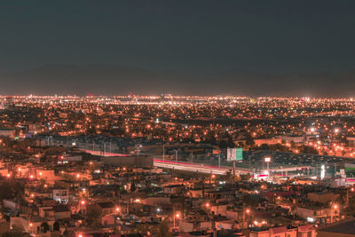 High angle view of illuminated cityscape against sky at night