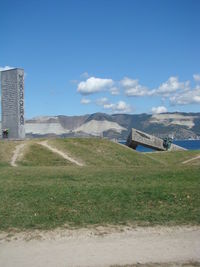 Scenic view of field by buildings against sky