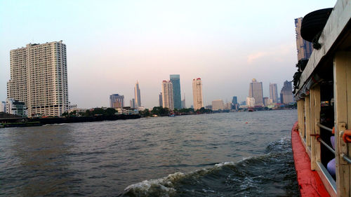 Buildings by sea against sky in city