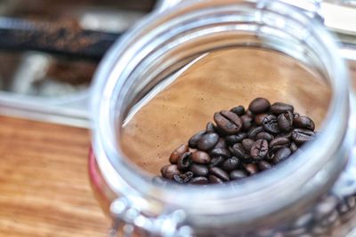High angle view of coffee beans in glass jar on table