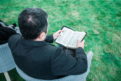Rear view of man sitting on grass