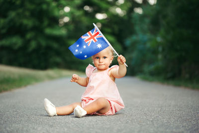 Caucasian baby girl waving australian flag. celebration of national australia day in january outdoor