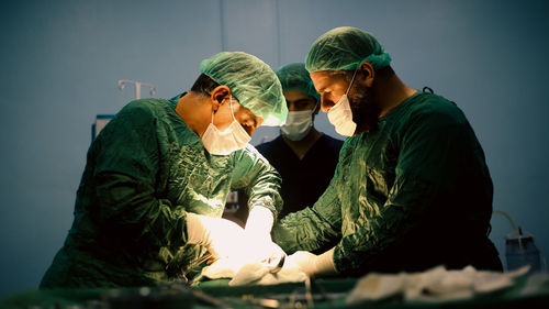 Medical team of surgeons in hospital doing minimal invasive surgical interventions. 