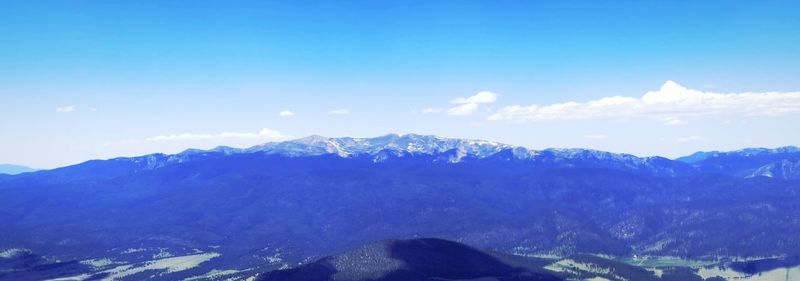 Scenic view of mountains against blue sky