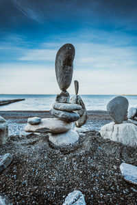 Stack of stones on beach against sky