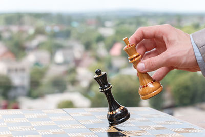 Close-up of hand holding chess pieces