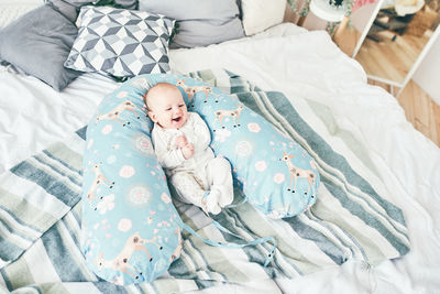 High angle view of baby sleeping on bed