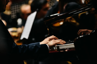 Midsection of man playing piano