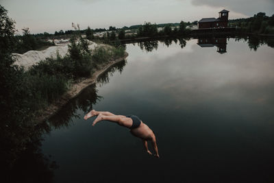 Reflection of person in lake against sky