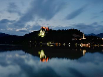 Scenic view of lake by buildings against sky