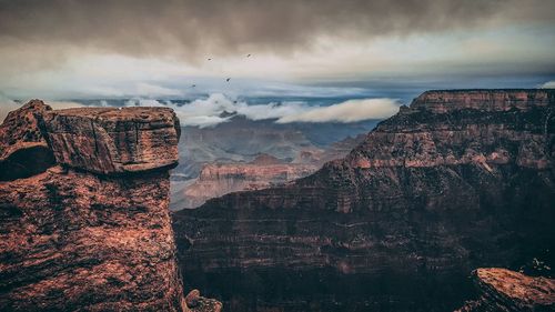 View of rock formation against cloudy sky