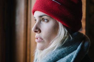 Thoughtful woman against wall in winter