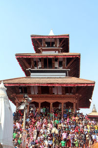 Low angle view of people against clear sky