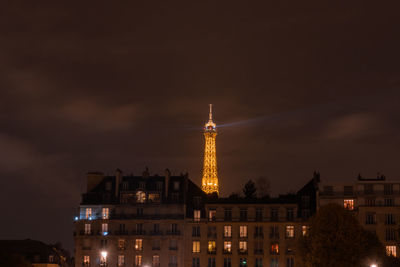 Low angle view of illuminated buildings against sky at night