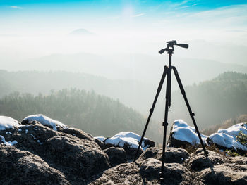 Empty tripod ready for creating time lapse in mountain winter landscape. frozen morning outdoor