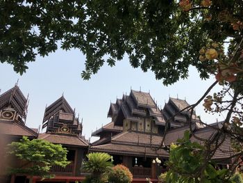 Low angle view of trees and buildings against sky