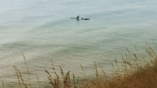 High angle view of man in sea against sky