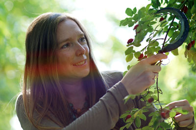 Close-up of young woman holding plant