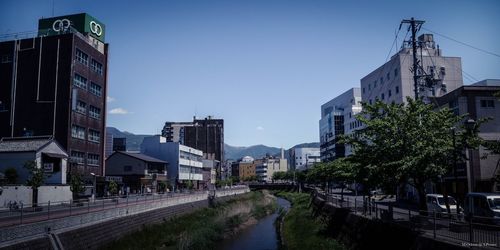 Canal amidst buildings against sky in city