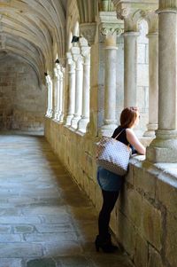 Side view of woman looking away while leaning on railing