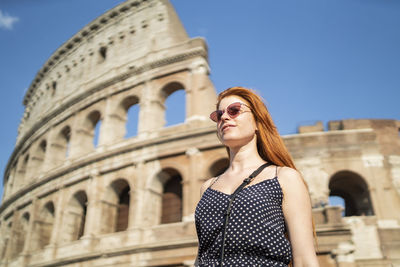 Pleased ginger traveler outside ancient building