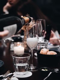 Close-up of bottle pouring champagne in flute on table