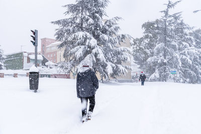 Full length of woman walking on snow covered field