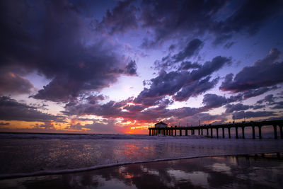 Pier over sea against sky during sunset