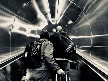 Rear view of couple standing at railroad station