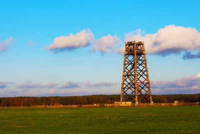 Old windmill on field against sky