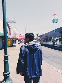 Rear view of woman standing against clear sky
