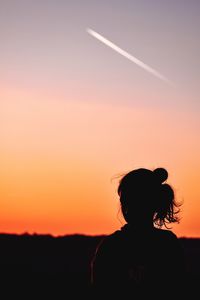 Silhouette girl at evening against sky