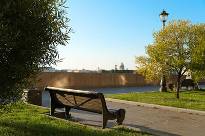 Rear view of man sitting on bench against sky