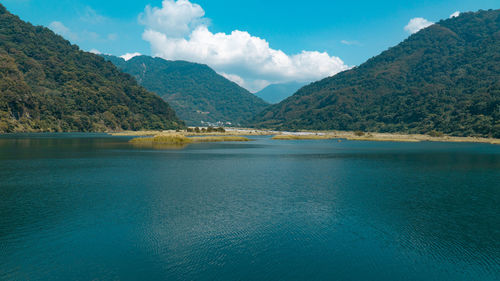 Scenic view of lake and mountains against sky