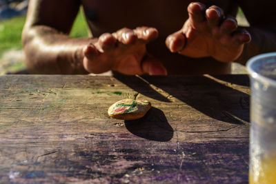 Midsection of man with stone on wooden table