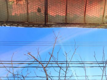 Low angle view of power lines against blue sky