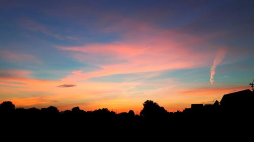 Silhouette trees against sky at sunset