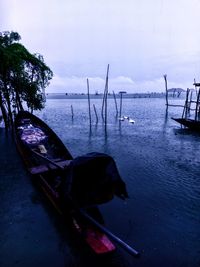 Boat moored on beach against sky