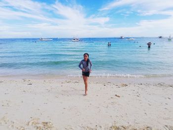 Full length of girl running at beach against sky