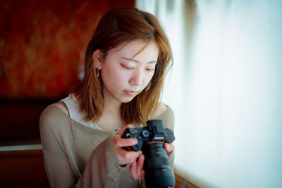 Young woman photographing with camera
